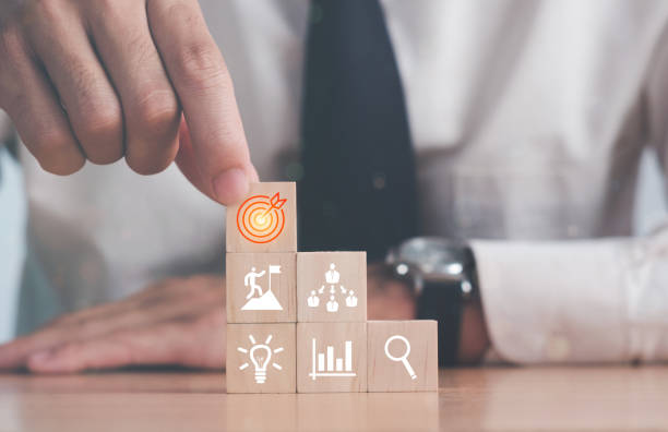 Targeting the business concept.business development concept. Businessman hand arranging wood block with icon business strategy and Action plan.