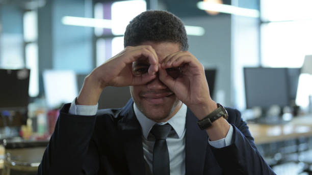 The Portrait of African Businessman making Binocular with Hand Gesture